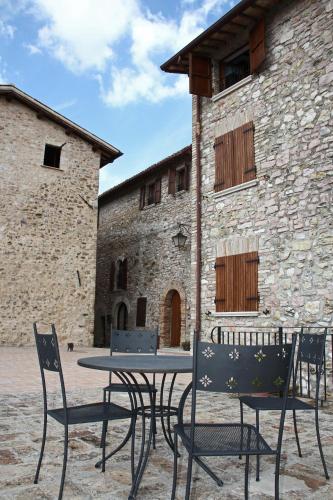 a table and chairs in front of a stone building at Il Castello Di Perchia in Crocemaroggia