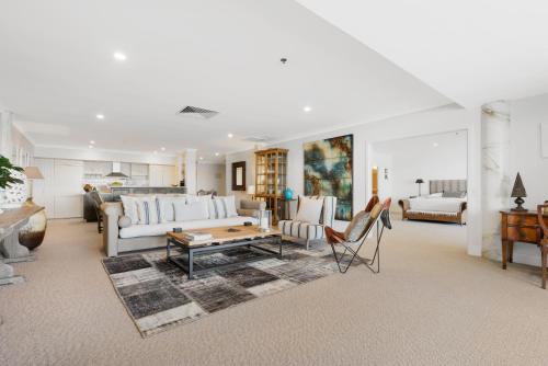 a living room with a couch and a table at Auckland Waterfront Serviced Apartments on Prince's Wharf in Auckland