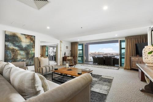 a living room with a couch and a table at Auckland Waterfront Serviced Apartments on Prince's Wharf in Auckland