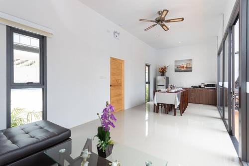 a living room with a table and a ceiling fan at The Thames Pool Access Resort & Villa - SHA Extra Plus in Chalong 