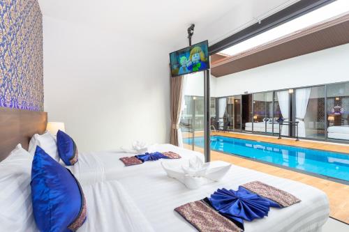 a hotel room with two beds and a swimming pool at The Thames Pool Access Resort & Villa - SHA Extra Plus in Chalong 