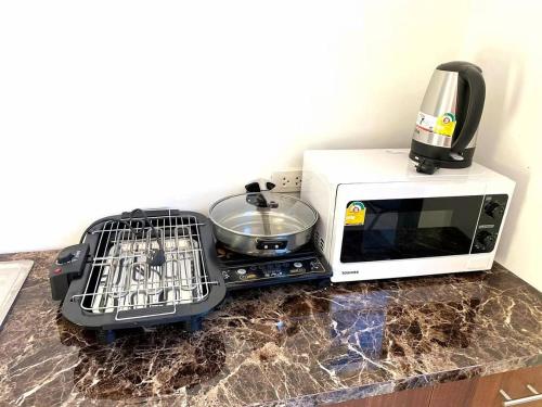 a microwave and a toaster sitting on a counter at The Thames Pool Access Resort & Villa - SHA Extra Plus in Chalong 