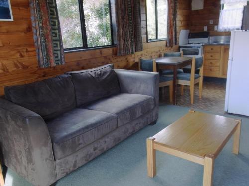 奧阿庫尼的住宿－奧斯小屋汽車旅館，客厅配有沙发和桌子