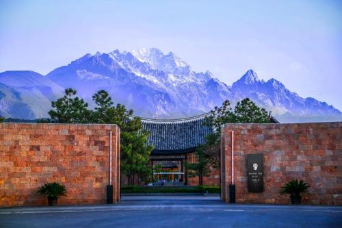 a building with a mountain range in the background at Banyan Tree Lijiang in Lijiang