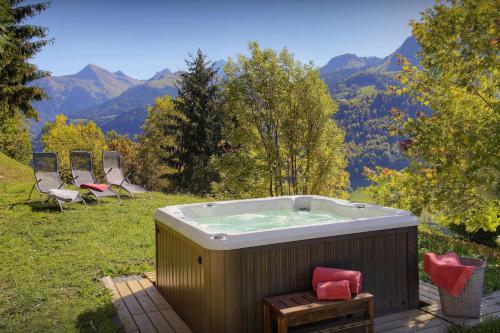 a hot tub with chairs and mountains in the background at Chalet Parakima - OVO Network in Manigod