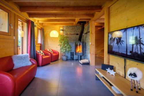 Les Villards-sur-ThônesにあるChalet Le Kitz - OVO Networkのリビングルーム(赤い家具、大画面テレビ付)