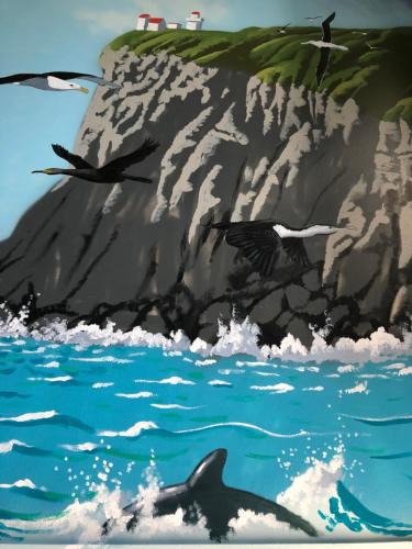 a painting of a dolphin in the water at Commodore Motel in Dunedin