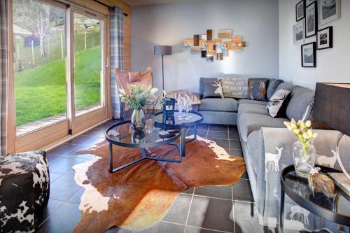 un salon avec un canapé et une table dans l'établissement Chalet Carter - OVO Network, à Saint-Jean-de-Sixt