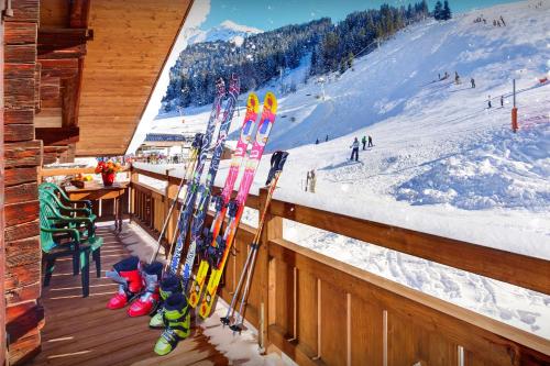 Um monte de esquis estão num corrimão numa cabana de esqui. em La Ferme à Juju - OVO Network em La Clusaz