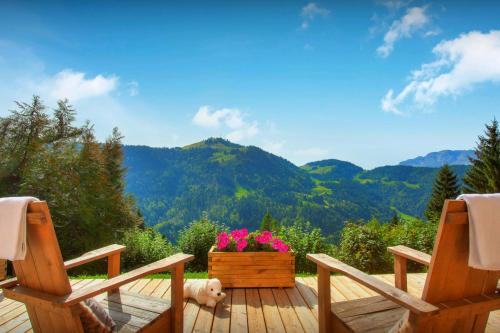 a dog sitting on a deck with two chairs at Chalet Charmar - OVO Network in La Clusaz