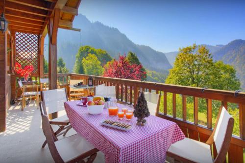 un tavolo con frutta e succo su un balcone con vista di Chalet Loisel - OVO Network a Saint-Jean-de-Sixt