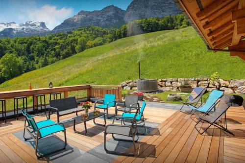 eine Terrasse mit Stühlen und einem Brunnen mit Bergen im Hintergrund in der Unterkunft Lodge La Source - OVO Network in Les Clefs