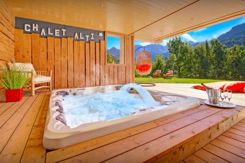 a jacuzzi tub sitting on a wooden deck at Chalet Alti - OVO Network in Le Grand-Bornand