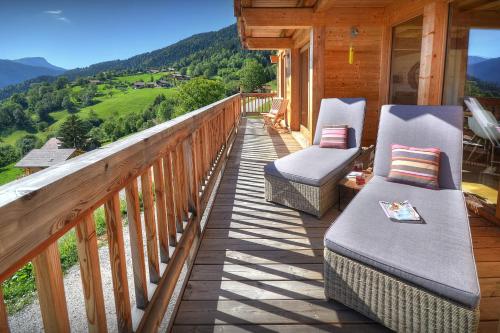 a balcony with two chairs and a view of the mountains at Chocolat Manigod - OVO Network in Manigod