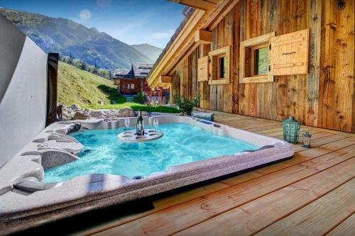 a hot tub on the deck of a house at Chalet Les Brévins - OVO Network in Manigod
