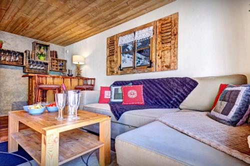 a living room with a couch and a table at Chalet Le Petit Mazot - OVO Network in La Clusaz