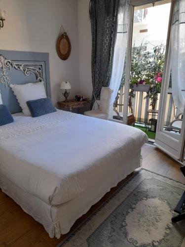 - une chambre avec un grand lit blanc et un balcon dans l'établissement Appartement 100m plages avec garage pour 2 pers, à Toulon