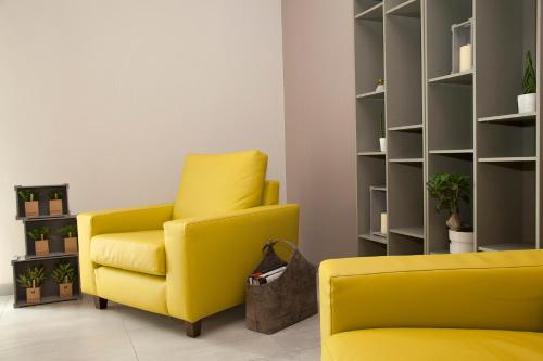 a yellow chair in a room with a shelf at Hotel Helvetia in Lido di Jesolo