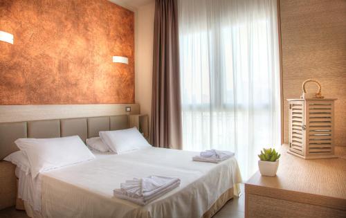 a bedroom with a bed with towels on it at Hotel Helvetia in Lido di Jesolo