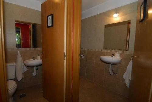 een badkamer met 2 wastafels, een toilet en een spiegel bij Tikaykilla Lodge & Wines in Maipú