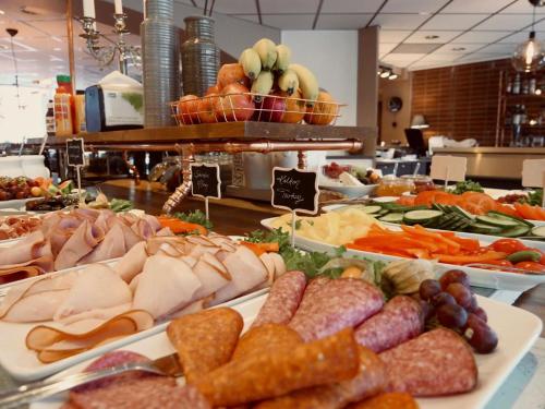a buffet filled with different types of meats and vegetables at Hotell Arkad in Västerås