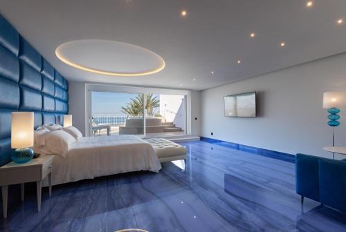 a bedroom with a bed and a view of the ocean at Grotta Palazzese Beach Hotel in Polignano a Mare