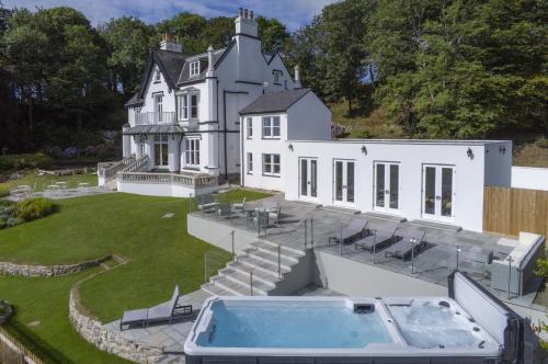 a large white house with a hot tub in the yard at Penally Manor - Luxurious Manor House - Tenby in Penally