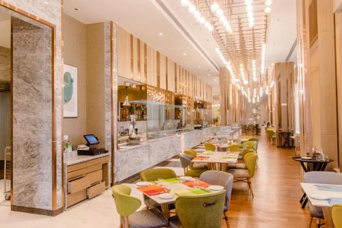 a restaurant with tables and chairs and a bar at Holiday Inn Chandigarh Zirakpur by IHG in Chandīgarh