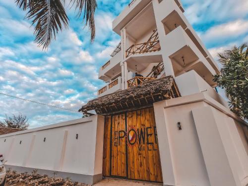 budynek z drewnianymi drzwiami z napisem "moc" w obiekcie Hi Zanzibar w mieście Paje