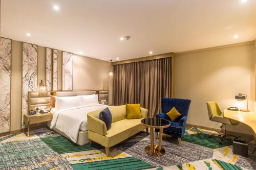 a hotel room with a bed and chairs and a desk at Holiday Inn Chandigarh Zirakpur by IHG in Chandīgarh