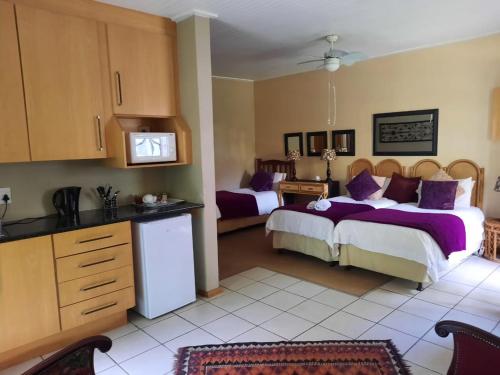 a bedroom with two beds with purple pillows at Fisant, Bokmakierie and Hoephoep Guest House in Bethlehem