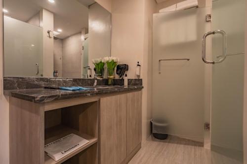a bathroom with a counter with a sink and a shower at Bayfront Hotel Cebu Capitol Site in Cebu City