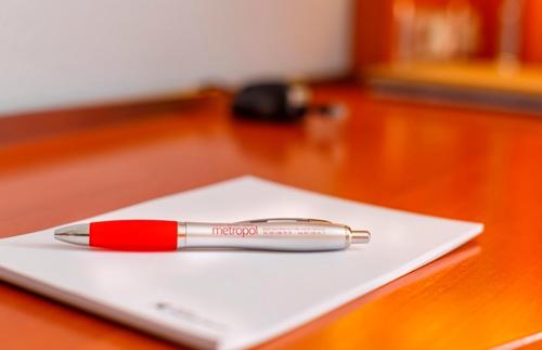 a red pen sitting on top of a white paper on a table at Hotel Metropol Basel in Basel