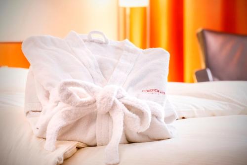 a pile of towels sitting on top of a bed at Hotel Metropol Basel in Basel