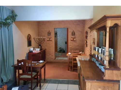 a living room with a table and a dining room at Fisant, Bokmakierie and Hoephoep Guest House in Bethlehem