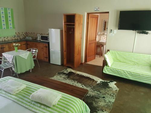 a room with two beds and a kitchen with a table at Crane Cottage in Colesberg