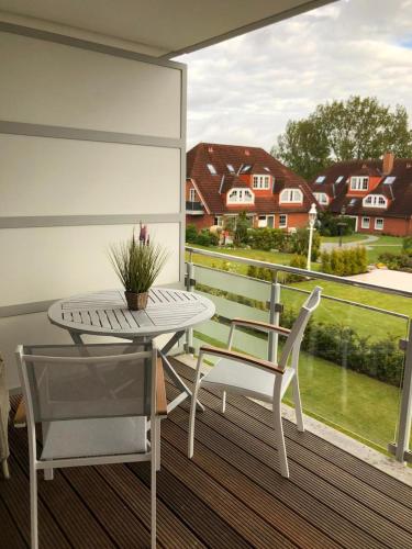 d'un balcon avec une table, des chaises et une fenêtre. dans l'établissement Kleine Auszeit, à Timmendorfer Strand
