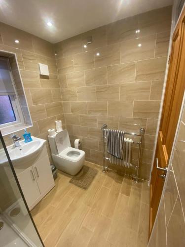 a bathroom with a toilet and a sink at BRIGSTOCK HOLIDAYS HOUSE in Manchester