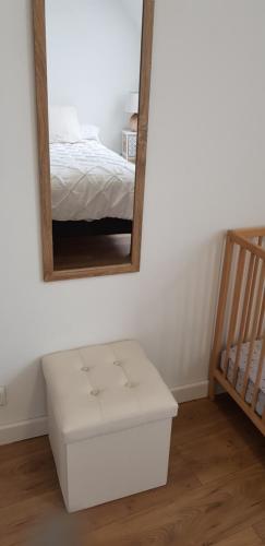 a white ottoman in front of a mirror in a bedroom at Gîte Lucian Mont-saint-michel in Moidrey
