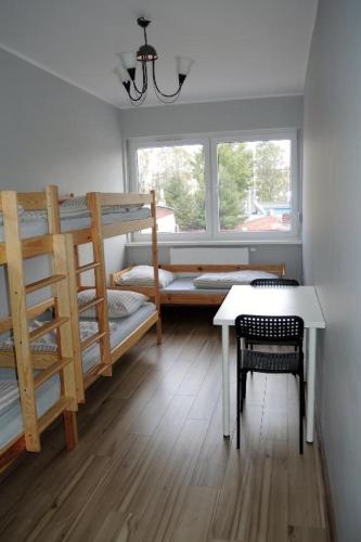 um quarto com 2 beliches, uma mesa e uma janela em Apartament Centrum Wągrowiec em Wągrowiec