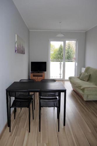 uma sala de estar com uma mesa e cadeiras e um sofá em Apartament Centrum Wągrowiec em Wągrowiec