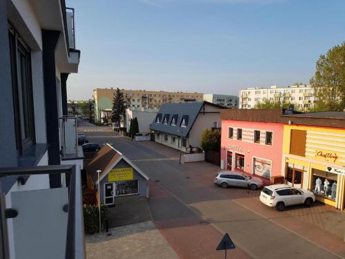 Apartament Centrum Wągrowiec في واغروويك: بلدة فيها سيارات متوقفة على شارع فيه مباني