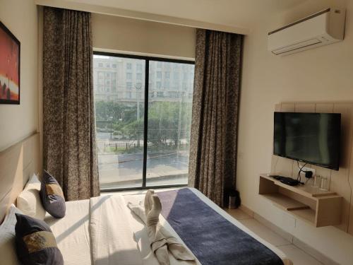 a hotel room with a large window and a bed at Hotel Hamilton in Zirakpur