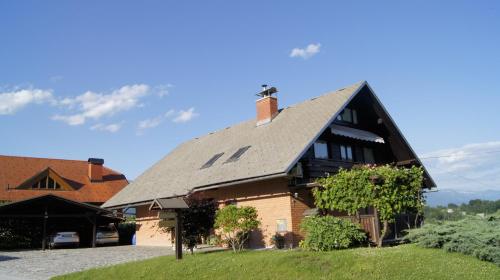a large wooden house with a gambrel roof at Apartments Janjusevic in Bled