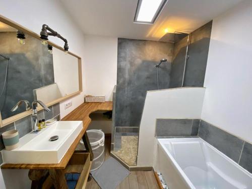 La salle de bains est pourvue d'un lavabo, d'une douche et d'une baignoire. dans l'établissement Maison dans quartier calme, à LʼIsle-sur-la-Sorgue