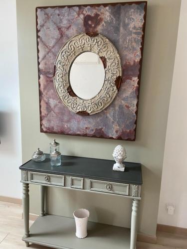 a dressing table with a mirror on a wall at Au coin des Hospices in Beaune