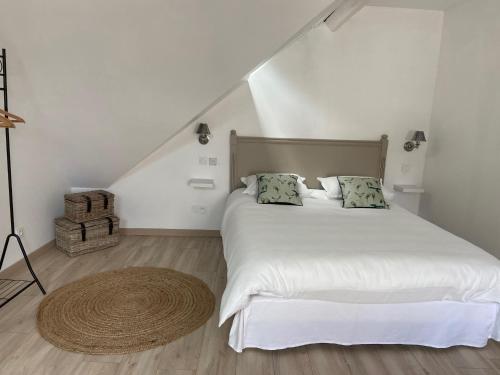 a bedroom with a white bed and a wooden floor at Au coin des Hospices in Beaune