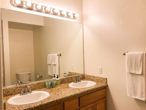 a bathroom with two sinks and a large mirror at Perfect Apt near UCLA w Parking Gym Pool WIFI in Westwood B3 in Los Angeles