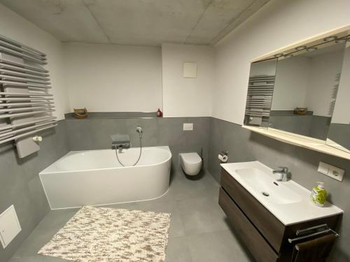 a bathroom with a tub and a sink and a toilet at Ferienwohnung an der Reitanlage in Glashütte