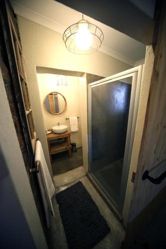 a bathroom with a walk in shower and a mirror at SOUSIE'S RUSTIC STAY in Polokwane